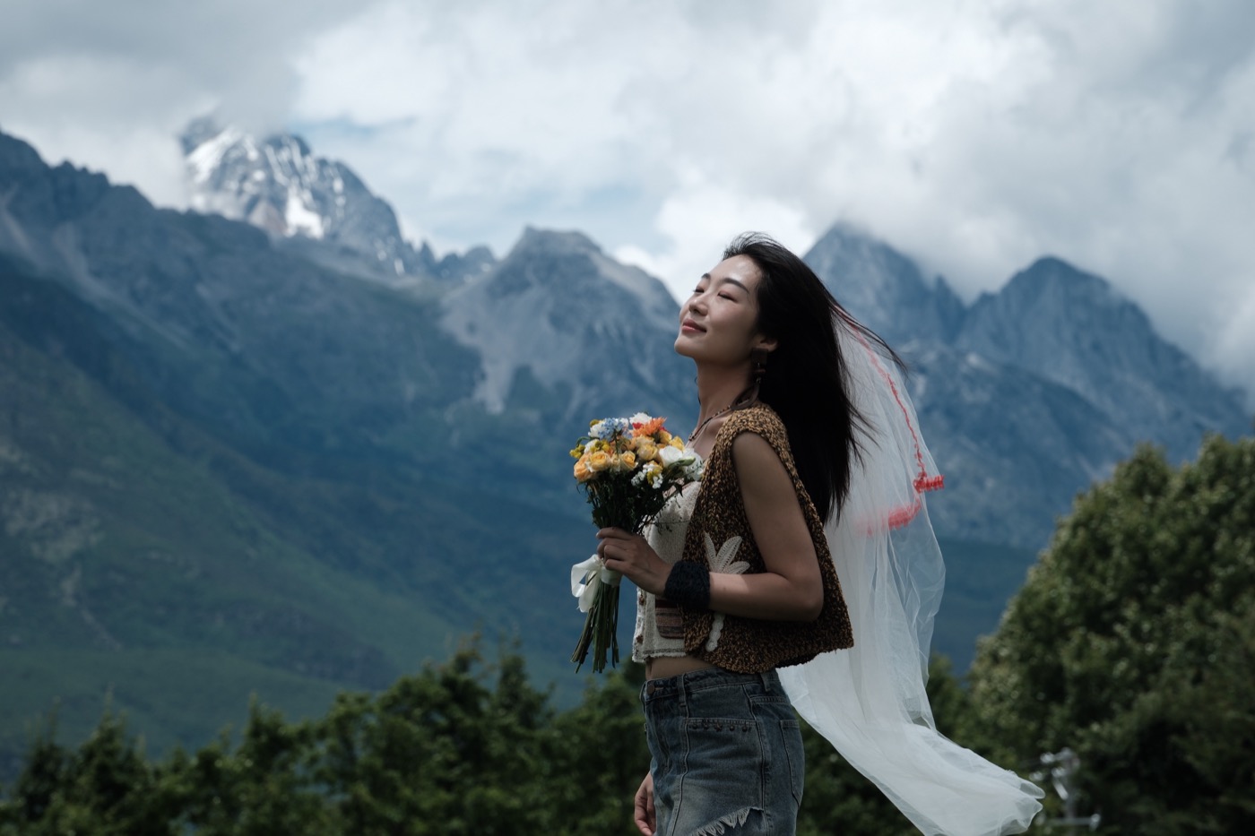 新娘捧花站在山风中。